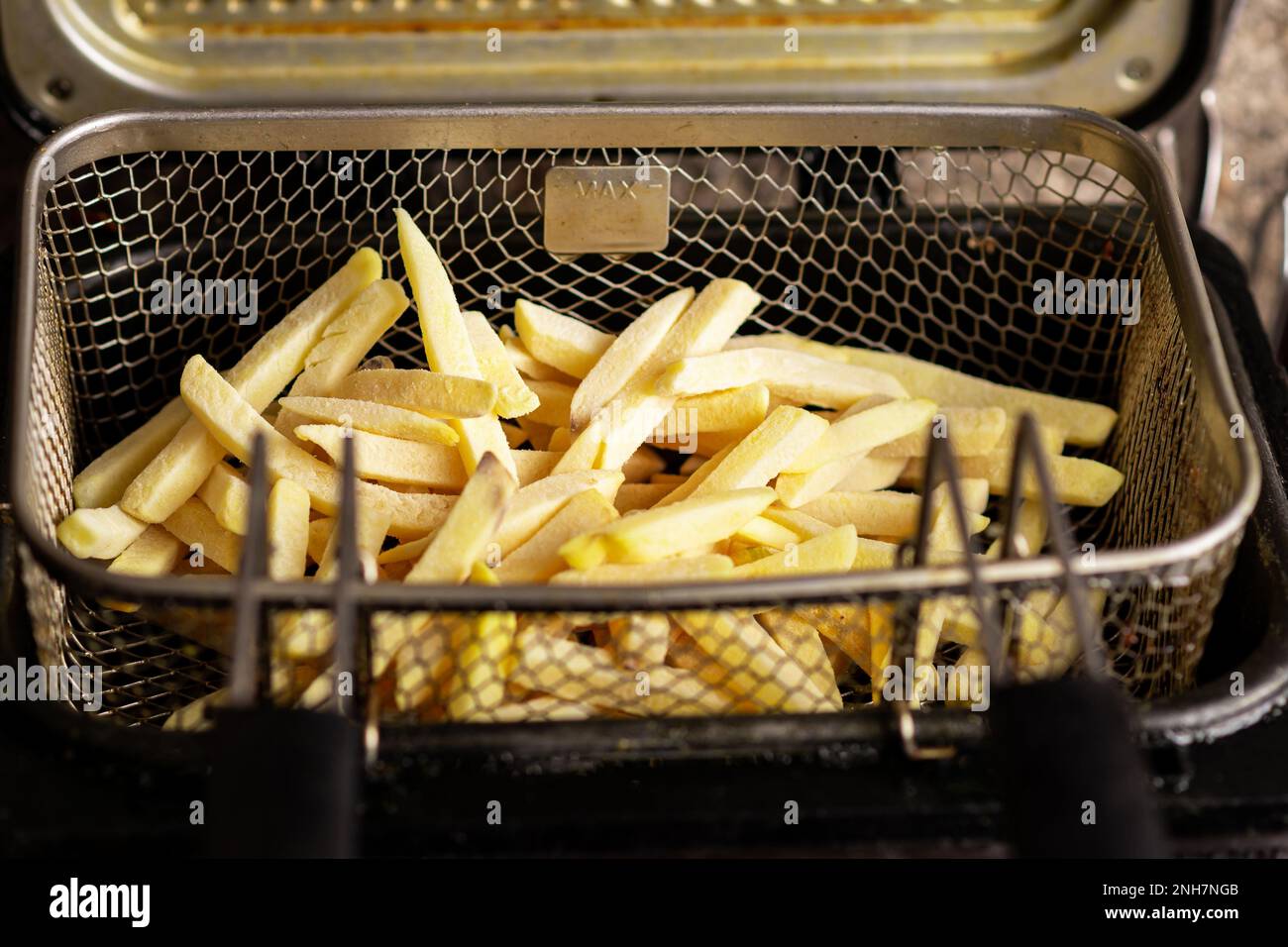 Frites surgelées dans un panier de friteuse. Produit semi-fini de pommes de  terre congelées. Préparation de la friture Photo Stock - Alamy