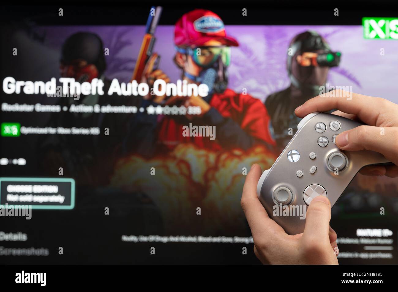 New york, Etats-Unis - 20 février 2023: Gamer commencer nouveau jeu en ligne GTA sur console Xbox avec joystick en main Banque D'Images