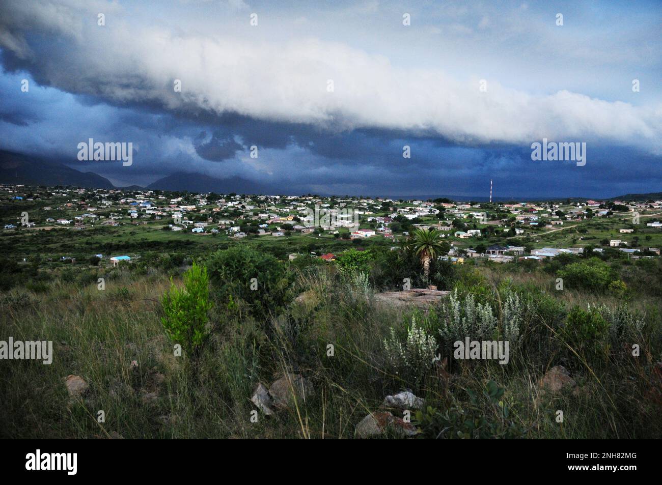 Des nuages de tempête s'accumulent sur un village africain alors que des conditions météorologiques extrêmes affligent certaines parties du sud-est de l'Afrique Banque D'Images