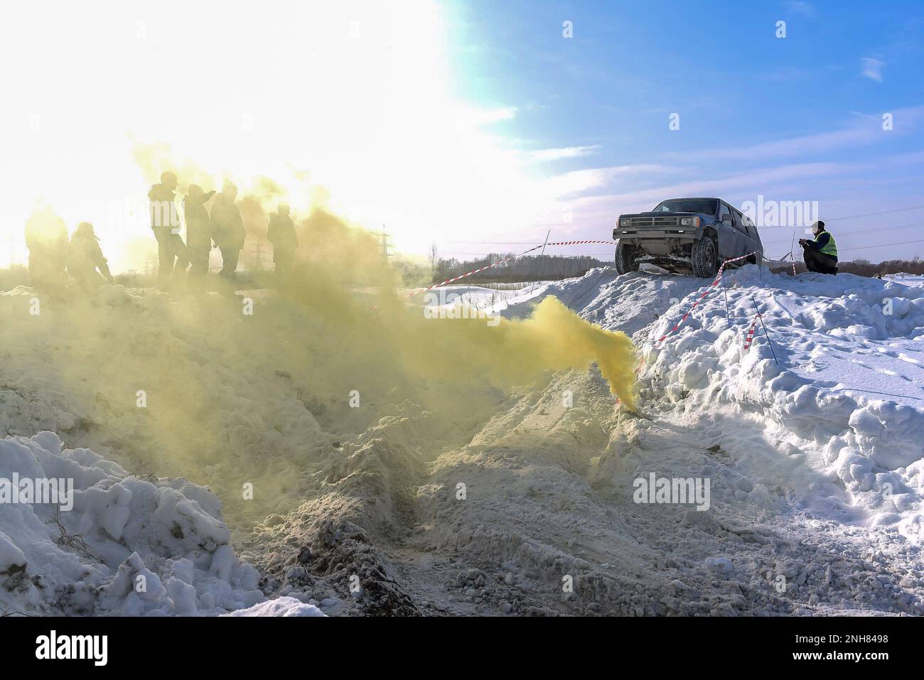 Le vus offroad « Toyota 4Runner Fourrunner 4x4 » se déplace sur une montagne de neige devant la fumée jaune colorée. Banque D'Images