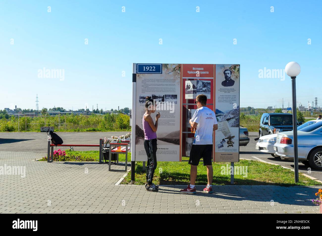 L'homme et la jeune fille touristique vont et regardent dans l'ombre des panneaux sites construction histoire Chuya autoroute dans l'été de l'Altaï Banque D'Images