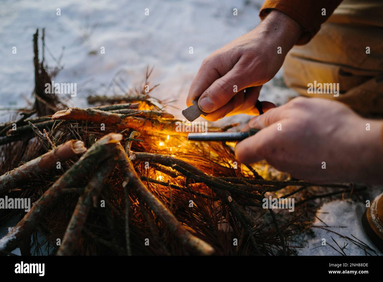 Gros plan de la main mâle commence le feu avec l'acier de feu de magnésium, gâche de feu. Concept de survie Banque D'Images