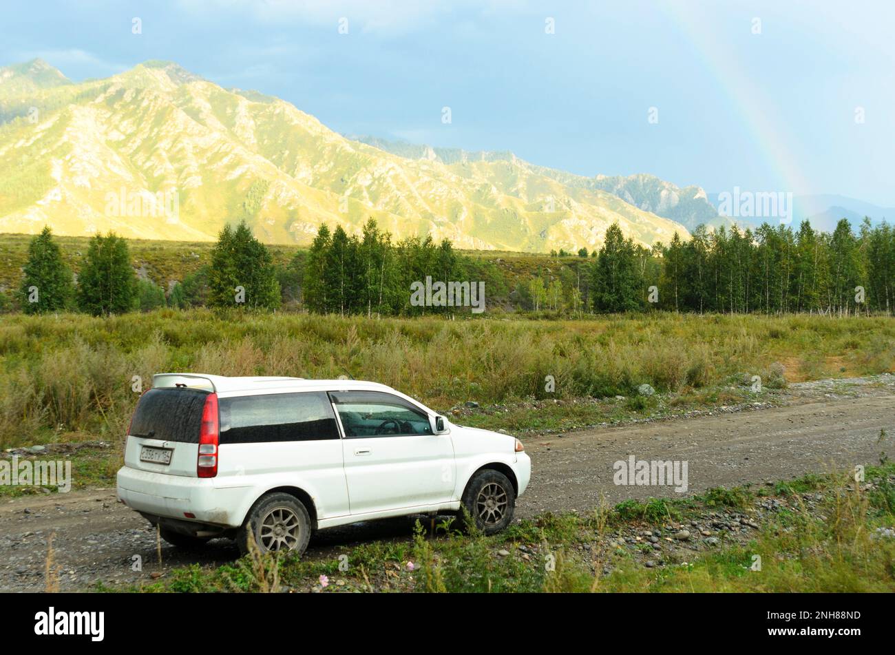 La marque automobile « Honda HR-V » se dresse sur une route de montagne avec des personnes au coucher du soleil à Altay Banque D'Images