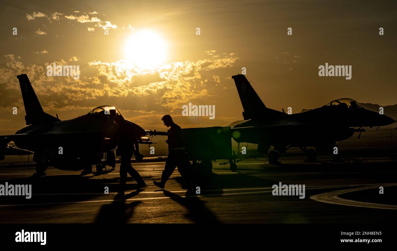 Les aviateurs d'entretien d'aéronefs de l'escadron de maintenance d'aéronefs 757th passent devant des chasseurs F-16 battant des faucon après avoir terminé une matinée de routine au cours du drapeau rouge Nellis 22-3 à la base aérienne de Nellis, Nevada, 21 juillet 2022. Au cours de la RF-N 22-3, l'escadron 64th des agresseurs utilise les faucon de combat F-16C/D pour imiter nos adversaires de stimulation afin d'affiner la réplication des menaces, d'appliquer des menaces avancées et des capacités de brouillage et d'augmenter les capacités de menace pour maximiser l'entraînement dans les environnements non permissifs. Banque D'Images