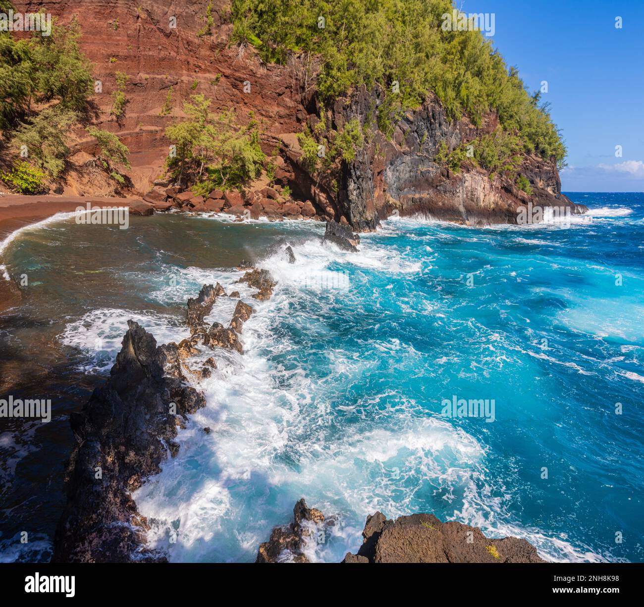 Sable rouge et vagues bleues de Kaihalulu Beach, Hana, Maui, Hawaii, États-Unis Banque D'Images