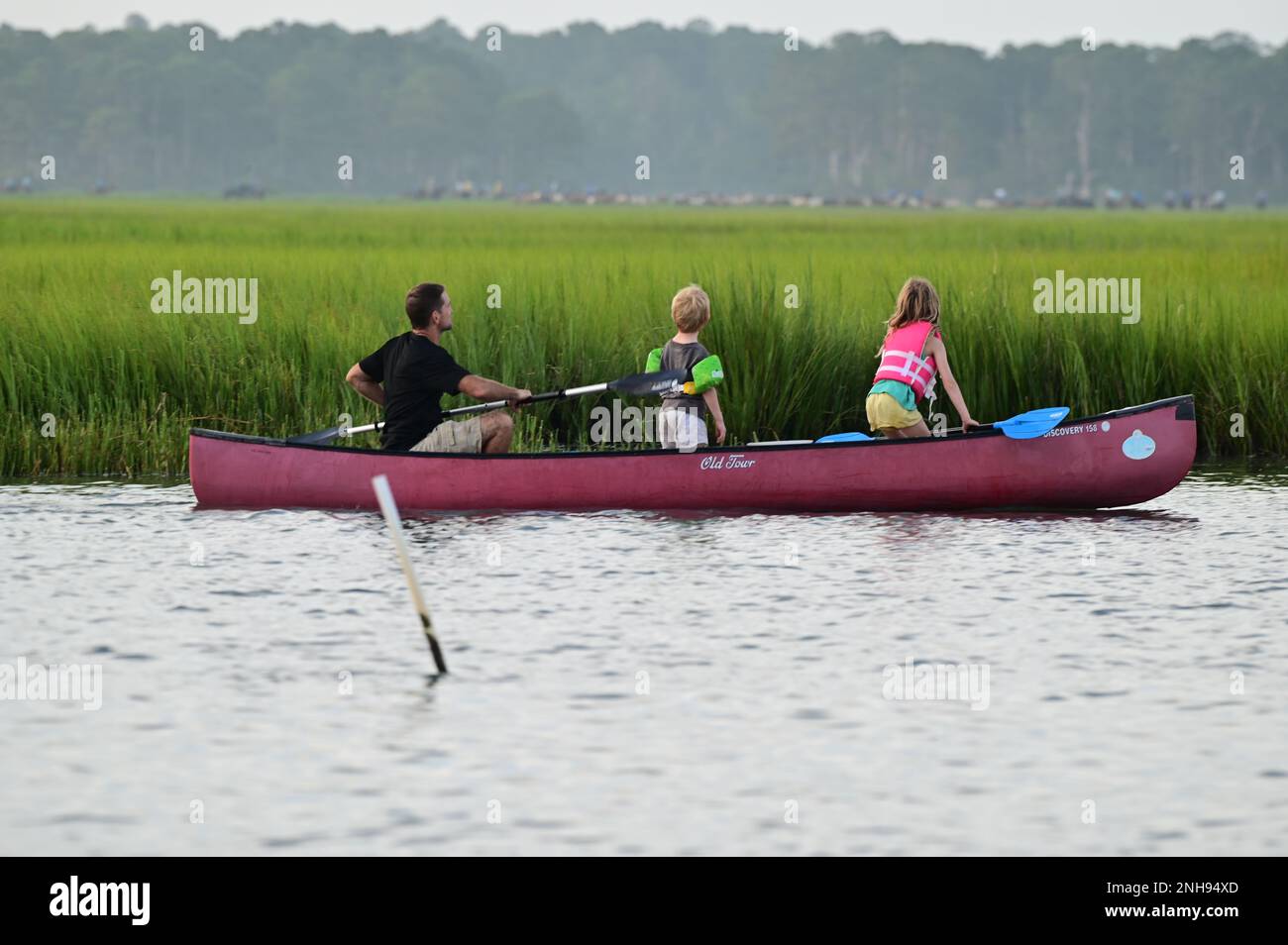 Une famille de kayakistes regardent les poneys commencer leur nage annuelle en poney à travers le chenal Assateague à l'île Chincoteague, au 27 juillet 2022. La station de garde côtière Chincoteague assure la sécurité à la nage de poney de Chincoteague chaque année. Banque D'Images