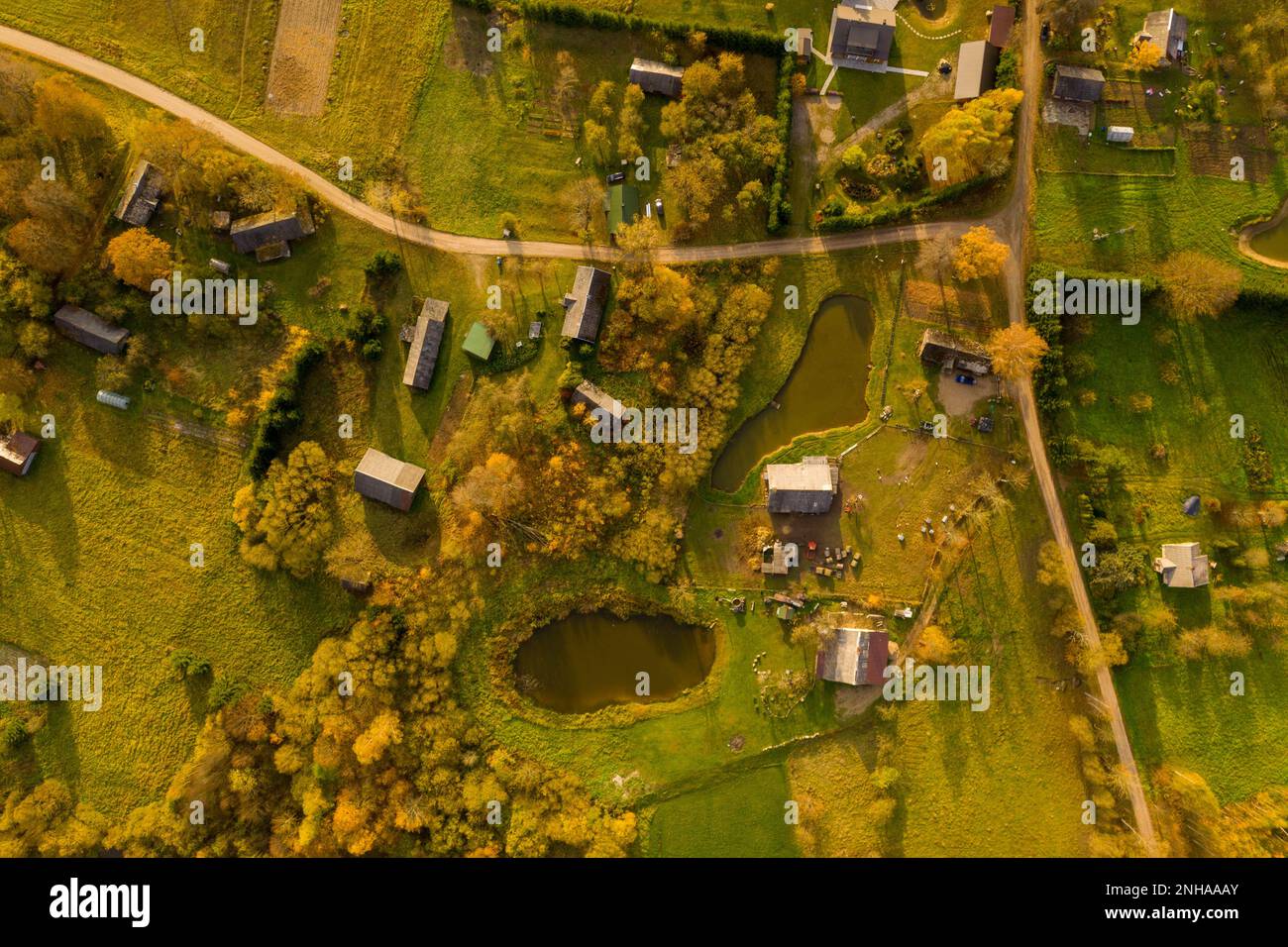 Photographie par drone de petits villages ruraux et de terres agricoles pendant la soirée d'été Banque D'Images