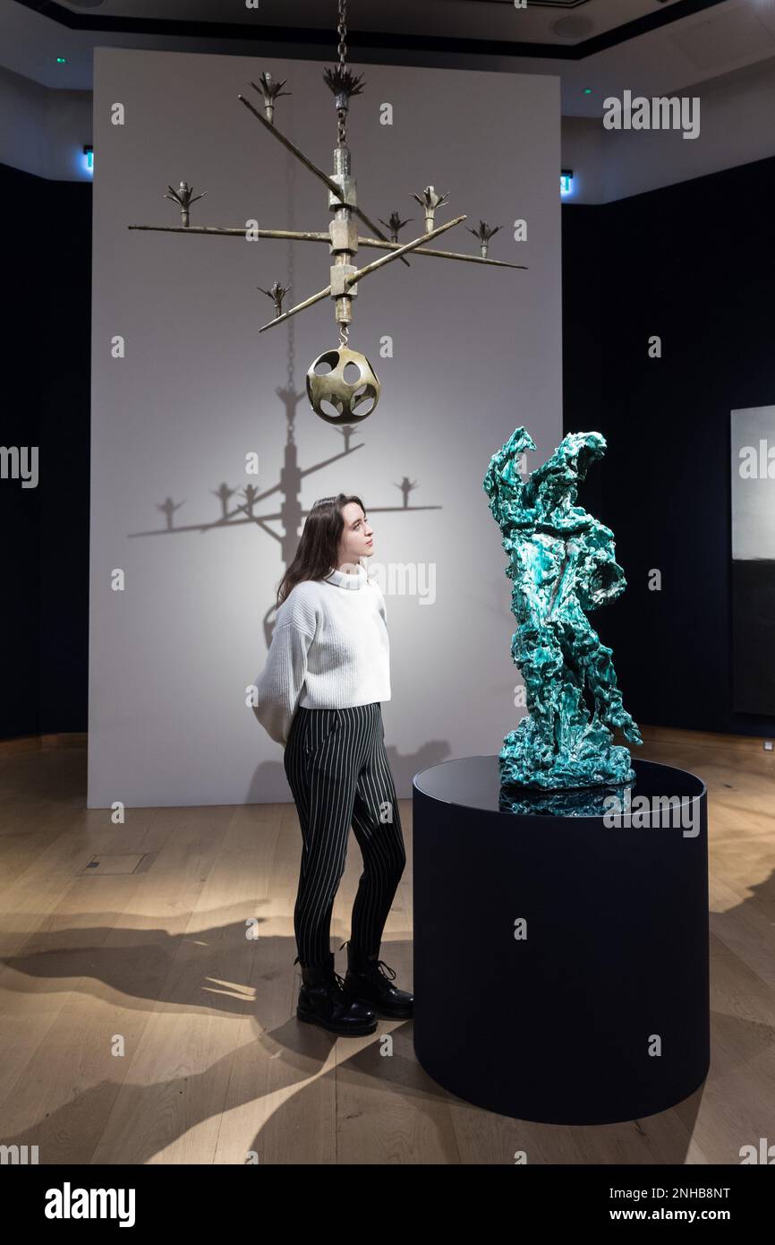 Londres, Royaume-Uni. 21st févr. 2023. LONDRES, ROYAUME-UNI - 21 FÉVRIER 2023: Un membre du personnel pose avec 'le guerrier (il Guerriero)' par Lucio Fontana, estimation: £900 000-1 500 000 et 'lustre pour Peter Watson' par Alberto Giacometti, estimation: £1 500 000-2 500 000 lors d'un appel photo pour le prochain 20th/21st Century Evening sale et l'art de la surréaliste soirée sale à Londres, Royaume-Uni sur 21 février 2023. (Photo de Wiktor Szymanowicz/NurPhoto) Credit: NurPhoto SRL/Alay Live News Banque D'Images