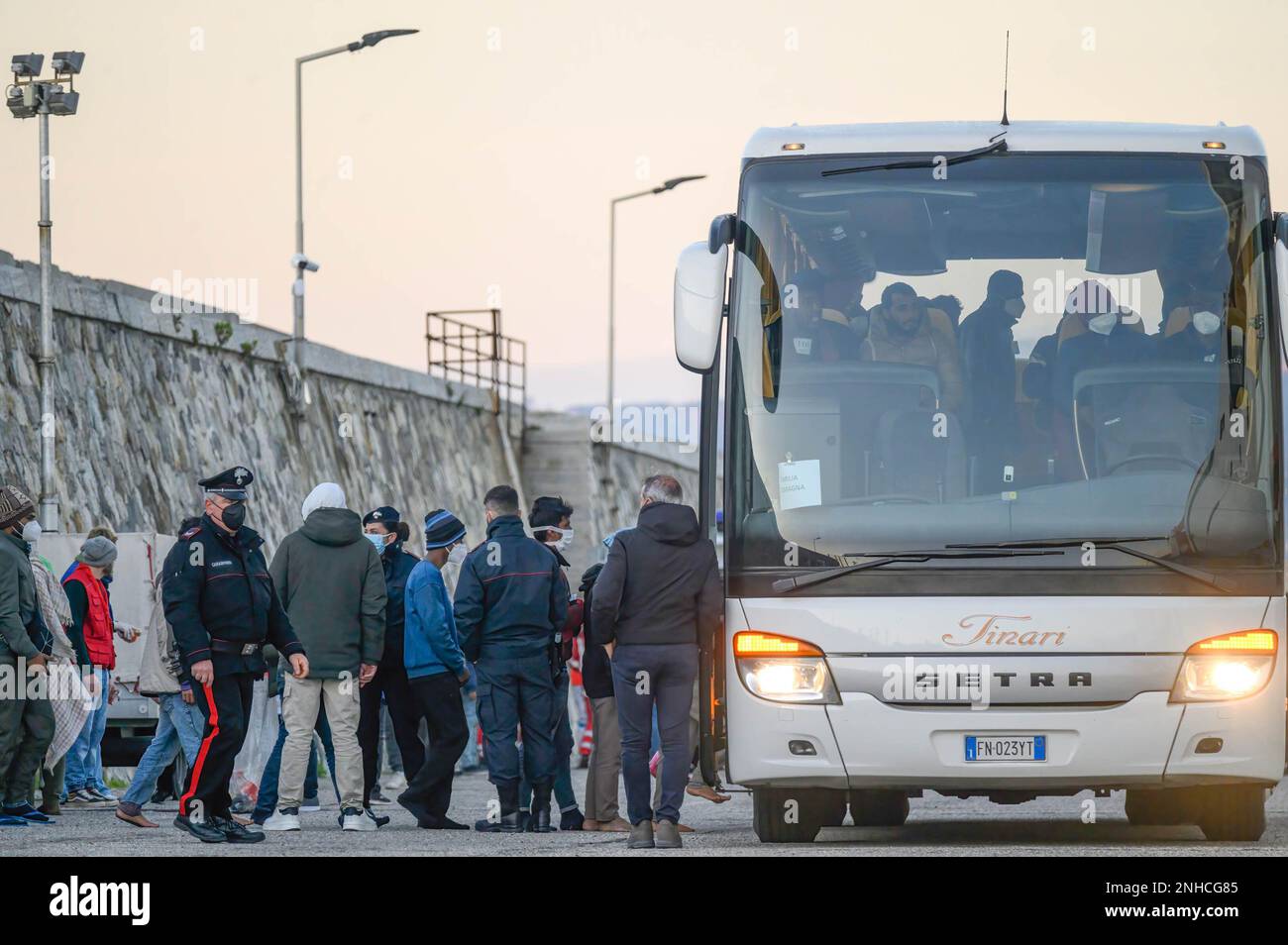 Les migrants vus debout en queque pour se rendre à l'autobus. Le navire de secours de la garde côtière italienne "Dattilo" est arrivé dans le port de Reggio Calabria avec 589 migrants, dont 131 femmes et 35 enfants, hébergés dans le hotspot surpeuplé de l'île de Lampedusa. Le hotspot, destiné à près de 400 personnes, a accueilli 3200 migrants sur 18 février, en provenance de Tunisie et de Libye. 40 migrants sur Dattilo resteront en Calabre, tandis que d'autres seront distribués dans d'autres régions italiennes. (Photo de Valeria Ferraro/SOPA Images/Sipa USA) Banque D'Images