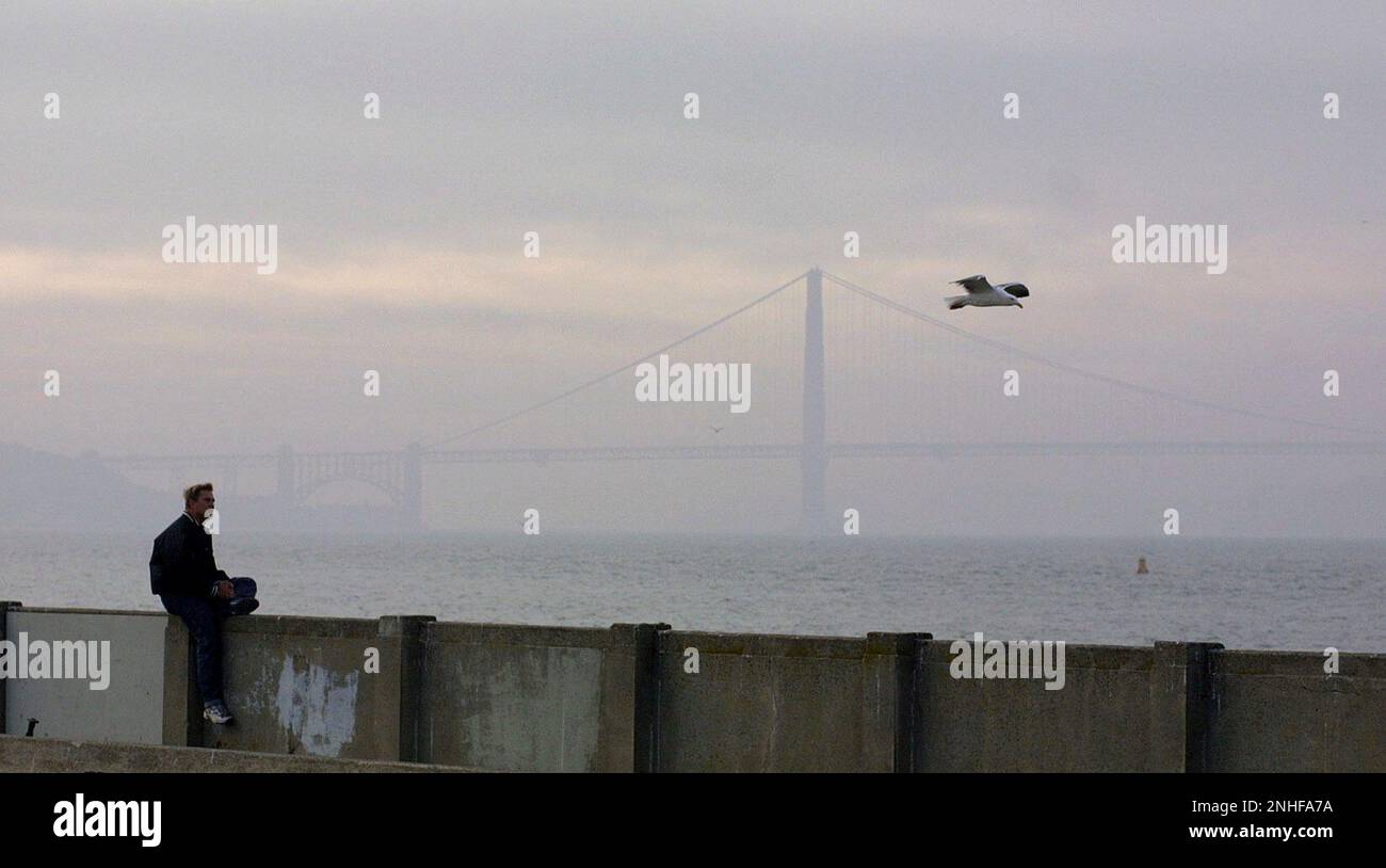 HAZY-C-27NOV00-MN-MAC Lee Wiglesworth visiting SF from Philadelphia sits along the Aquatic Park Pier under hazy afternoon skies. Wiglesworth said he was enjoying the warm weather hear since it was 18 degrees a few days ago when he left Philadelphia. by Michael Macor/The Chronicle (MICHAEL MACOR/San Francisco Chronicle via AP) Banque D'Images