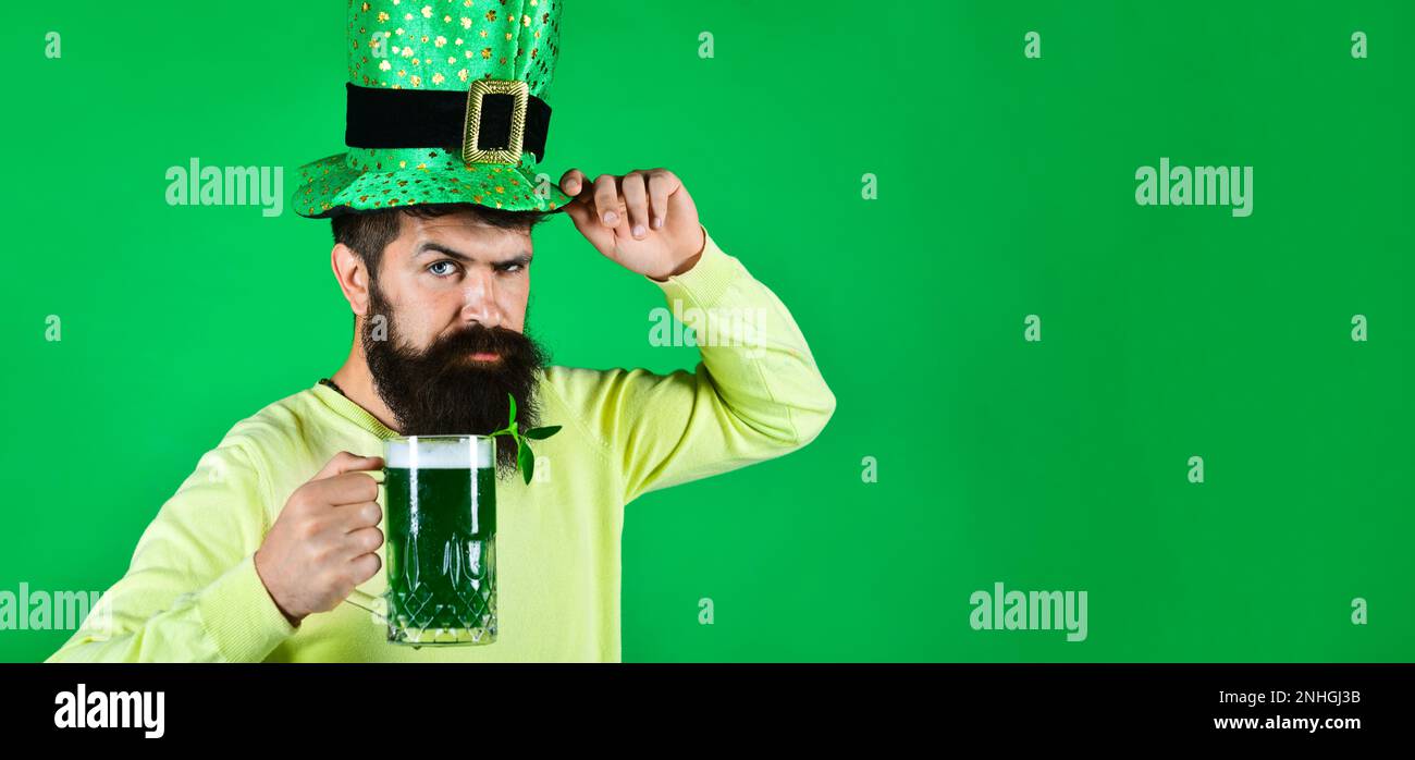 Fête pab de la Fête de Patrick. Homme barbu en chapeau de lepreun avec bière verte. Barbu dans un chapeau vert en buvant de la bière verte. Tradition irlandaise. Patrick, homme de la journée Banque D'Images