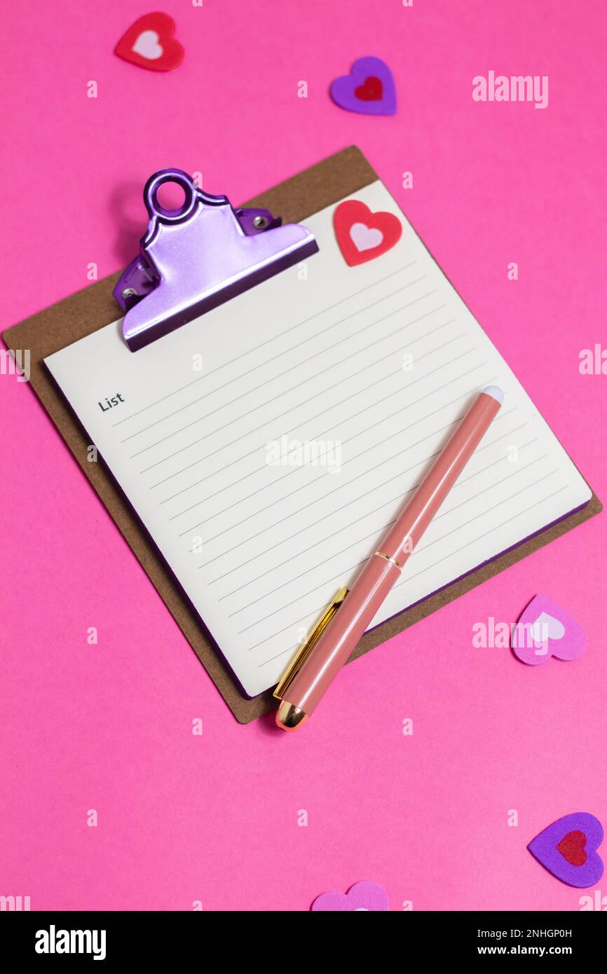 Bureau rose pour femmes. Bloc-notes, stylo, autocollants sur fond rose. Flat lay, vue de dessus, espace de copie, bannière Banque D'Images