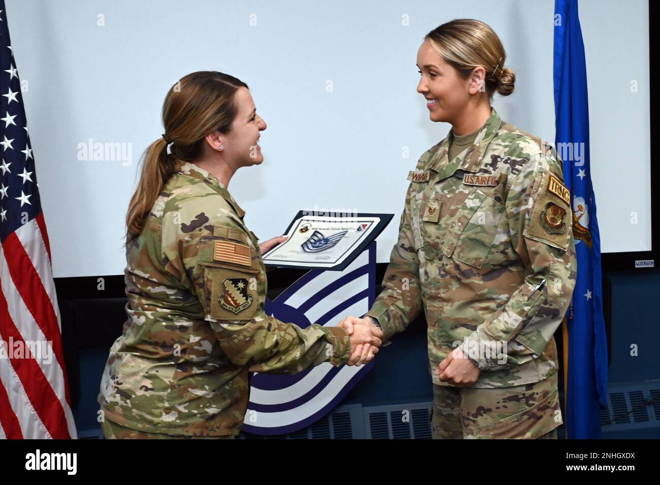 Personnel. Le Sgt Emily Williams, à droite, entraîneur de l’unité de l’escadron 66th des forces de sécurité, serre la main avec le colonel Taona Enriquez, commandant de l’installation, lors d’un événement technique de libération de sergeant à la base aérienne Hanscom, Mass., 29 juillet. Les responsables de la Force aérienne ont sélectionné 5 430 sergents pour la promotion au service technique, dont cinq à la Hanscom AFB. Banque D'Images