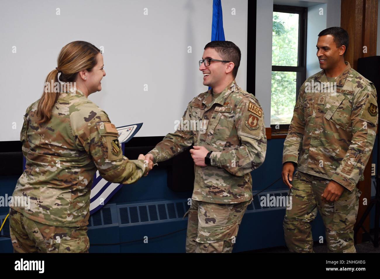 Personnel. Le Sgt Ernest TrueBlood, 66th Groupe de la base aérienne Bureau du juge-avocat NCO en charge de la justice militaire, serre la main avec le colonel Taona Enriquez, commandant de l'installation, lors d'un événement de libération de sergent technique à la base de la Force aérienne Hanscom, Mass., 29 juillet, tandis que le Sgt. Principal Alan Weary, à droite, chef du commandement de l'installation, regarde. Les responsables de la Force aérienne ont sélectionné 5 430 sergents pour la promotion au service technique, dont cinq à la Hanscom AFB. Banque D'Images