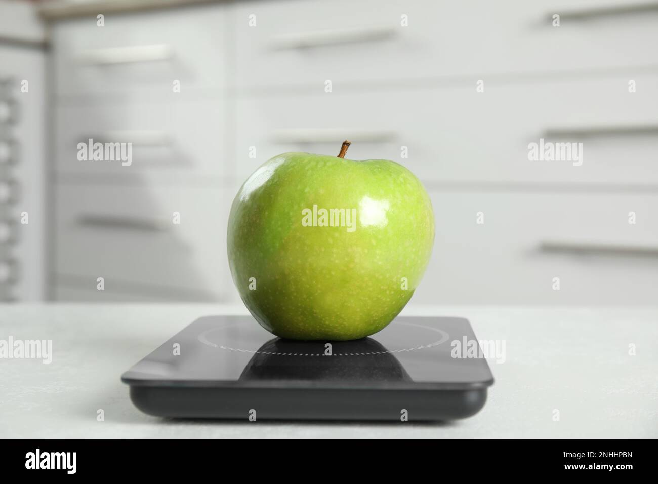 Pomme verte et balance numérique moderne sur table Banque D'Images