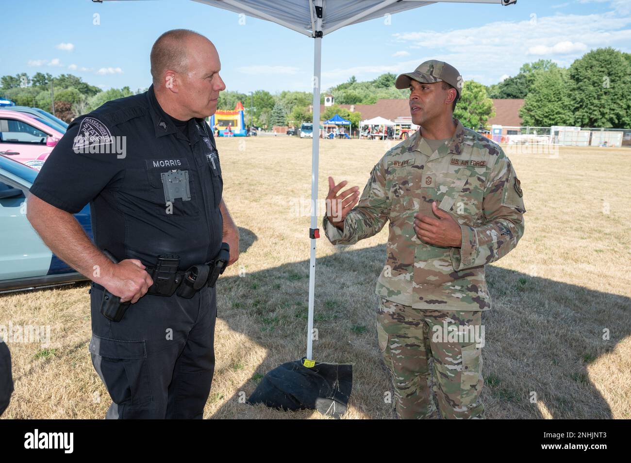 Le sergent Jay Morris de la police d'État du Massachusetts et le sergent-chef Alan Weary, chef du commandement de l'installation, discutent lors d'une soirée nationale à la base aérienne de Hanscom, au Massachusetts, au 29 juillet. L'événement a été organisé par l'escadron 66th des Forces de sécurité afin de relier les forces de l'ordre locales et les autres premiers intervenants à la communauté de la base. Banque D'Images