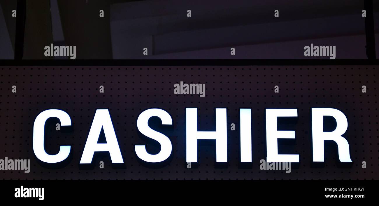 Une affiche indique « CAISSIER » en majuscules sur fond noir Banque D'Images
