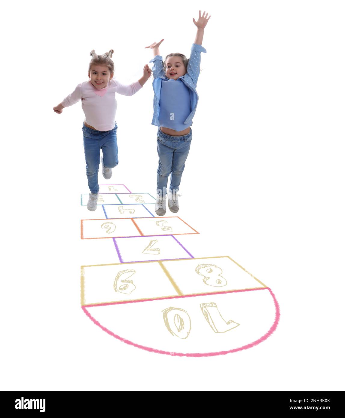 Mignons petites filles jouant le hopscotch sur fond blanc Banque D'Images