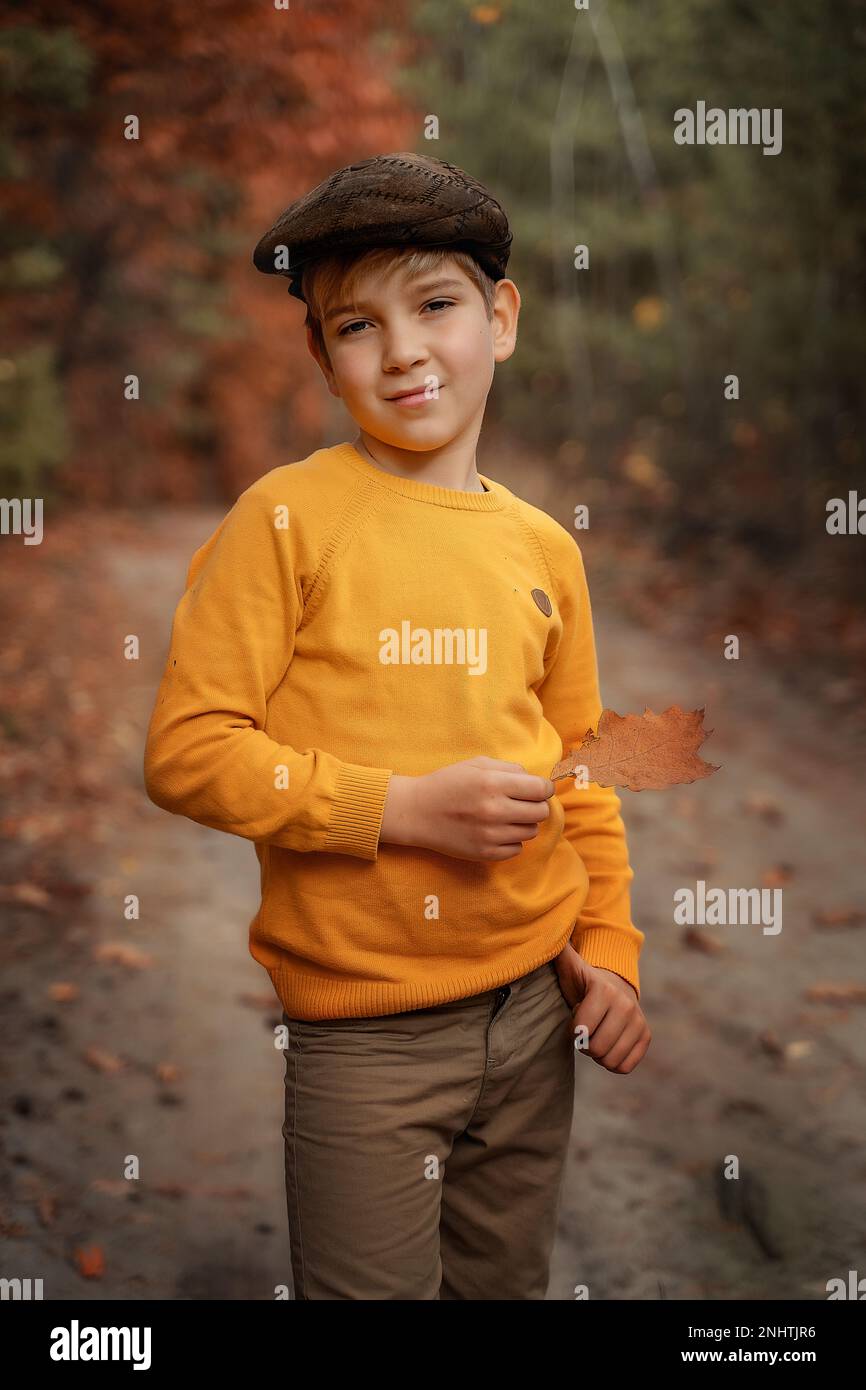 Mode pour enfants, style rétro. Un petit garçon souriant dans un manteau et  une casquette de style rétro se tient et sourit. Copier l'espace Photo  Stock - Alamy