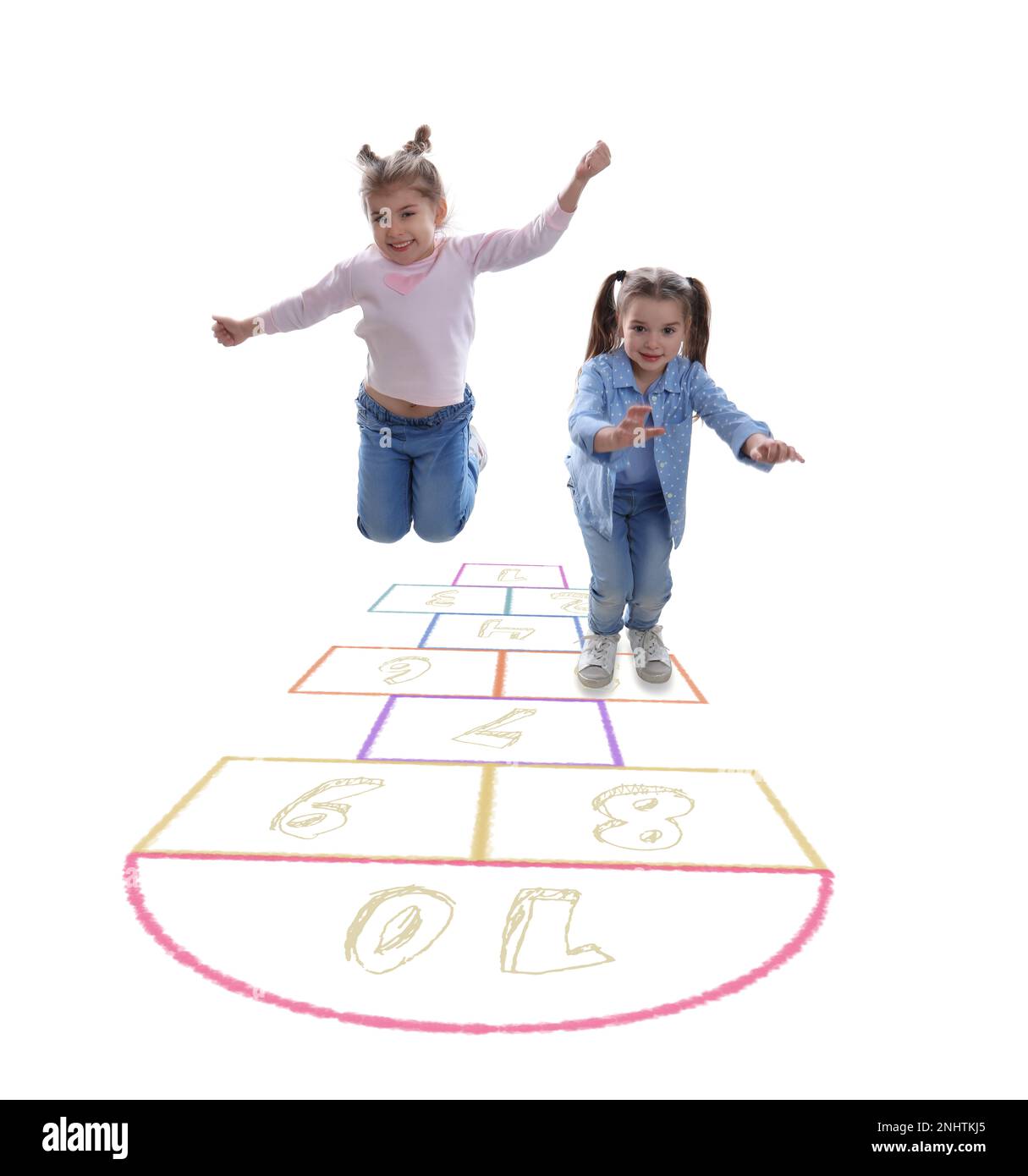 Mignons petites filles jouant le hopscotch sur fond blanc Banque D'Images