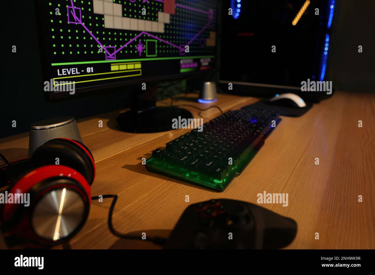 Clavier RVB, ordinateur moderne et casque sur table en bois à l'intérieur Banque D'Images