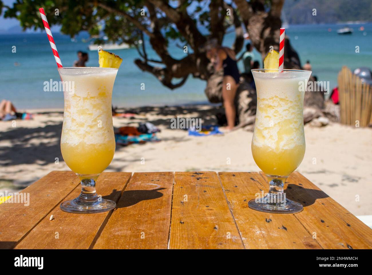 Deux cocktails d'alcool frais sur la plage. Pina colada froide sur fond marin. Deux cocktails d'ananas frais avec de la paille et de la glace. Banque D'Images