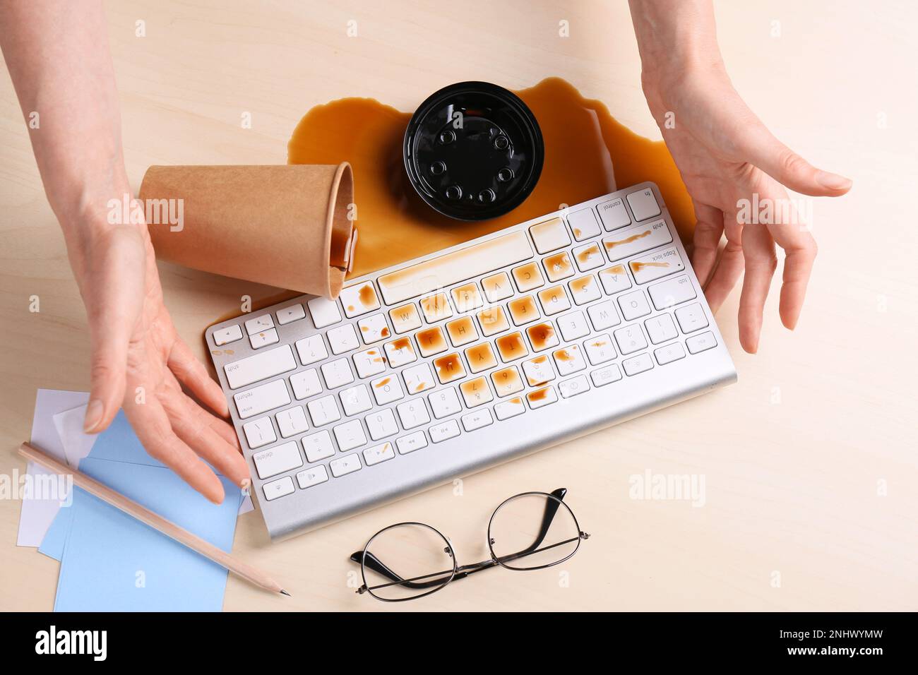 Femme avec du café renversé sur son lieu de travail, gros plan Banque D'Images Femme avec du café renversé sur son lieu de travail, gros plan Banque D'Images