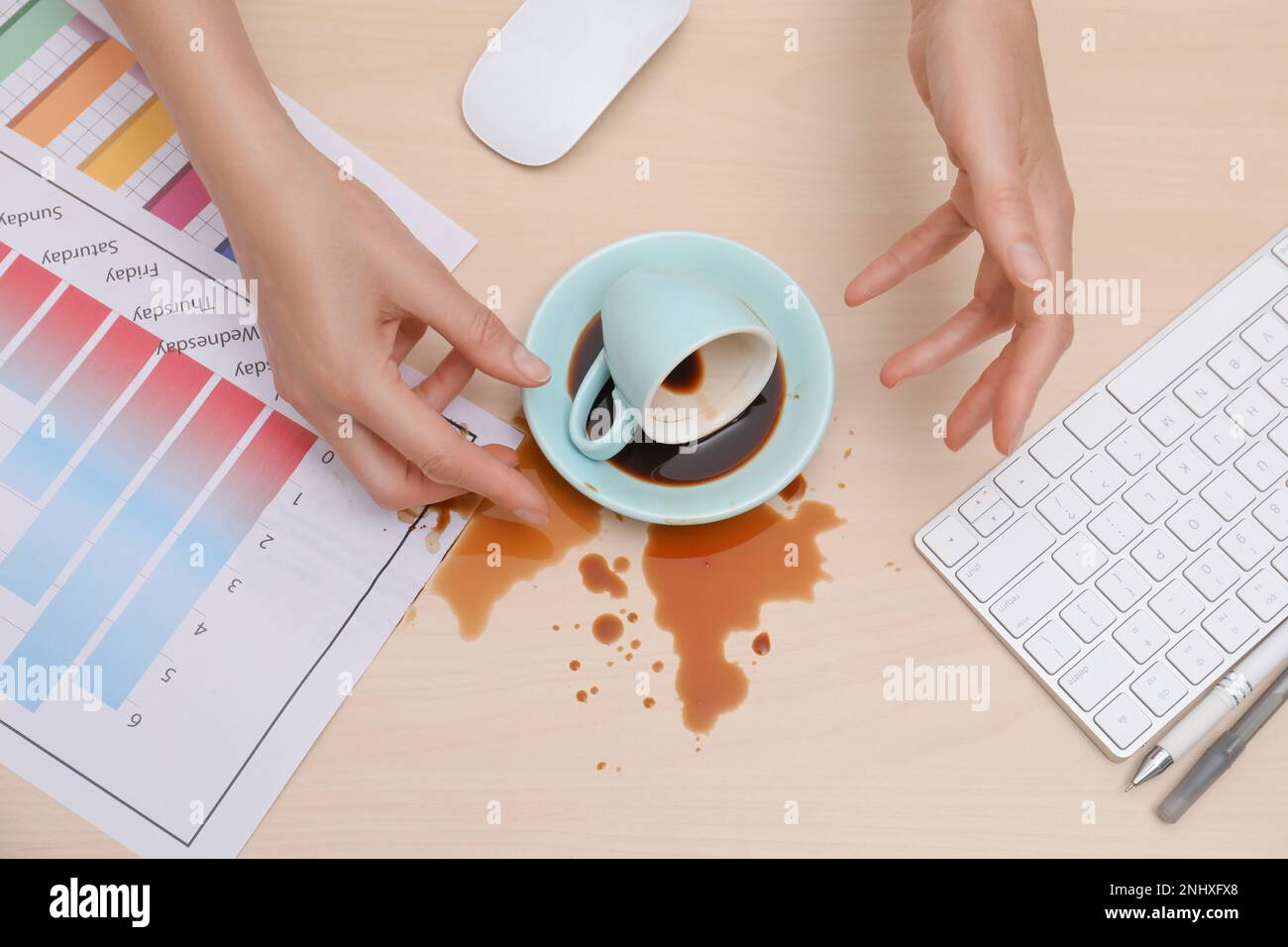Gros plan d'une femme a renversé du café sur un bureau en bois, vue de dessus Banque D'Images Gros plan d'une femme a renversé du café sur un bureau en bois, vue de dessus Banque D'Images