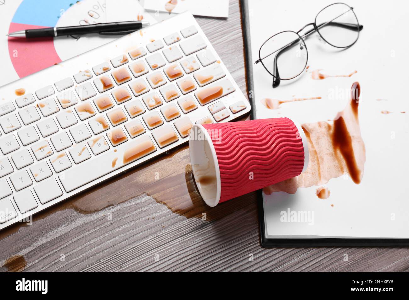 Tasse de café renversé sur le clavier d'ordinateur sur le bureau en bois, au-dessus de la vue Banque D'Images Tasse de café renversé sur le clavier d'ordinateur sur le bureau en bois, au-dessus de la vue Banque D'Images