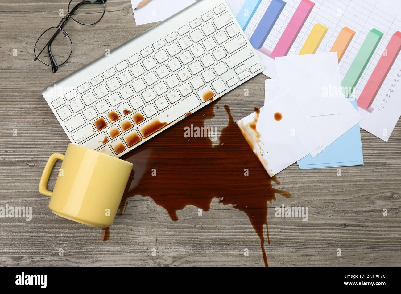Tasse de café renversé sur le clavier de l'ordinateur sur le bureau en bois, plat Banque D'Images Tasse de café renversé sur le clavier de l'ordinateur sur le bureau en bois, plat Banque D'Images