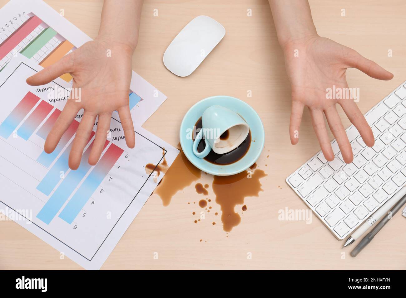Gros plan d'une femme a renversé du café sur un bureau en bois, vue de dessus Banque D'Images Gros plan d'une femme a renversé du café sur un bureau en bois, vue de dessus Banque D'Images
