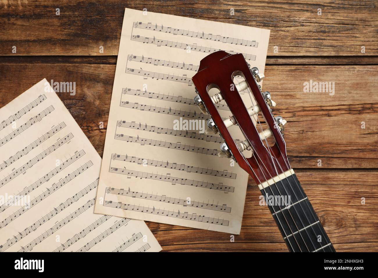 Composition avec guitare et notes de musique sur table en bois, plat Banque D'Images