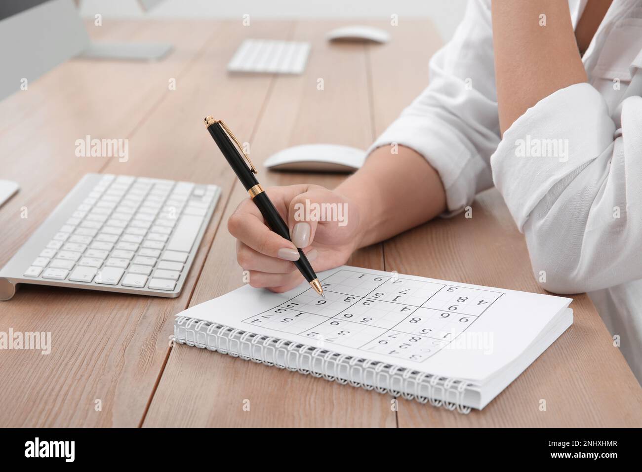 Femme résolvant sudoku puzzle à la table, gros plan Banque D'Images
