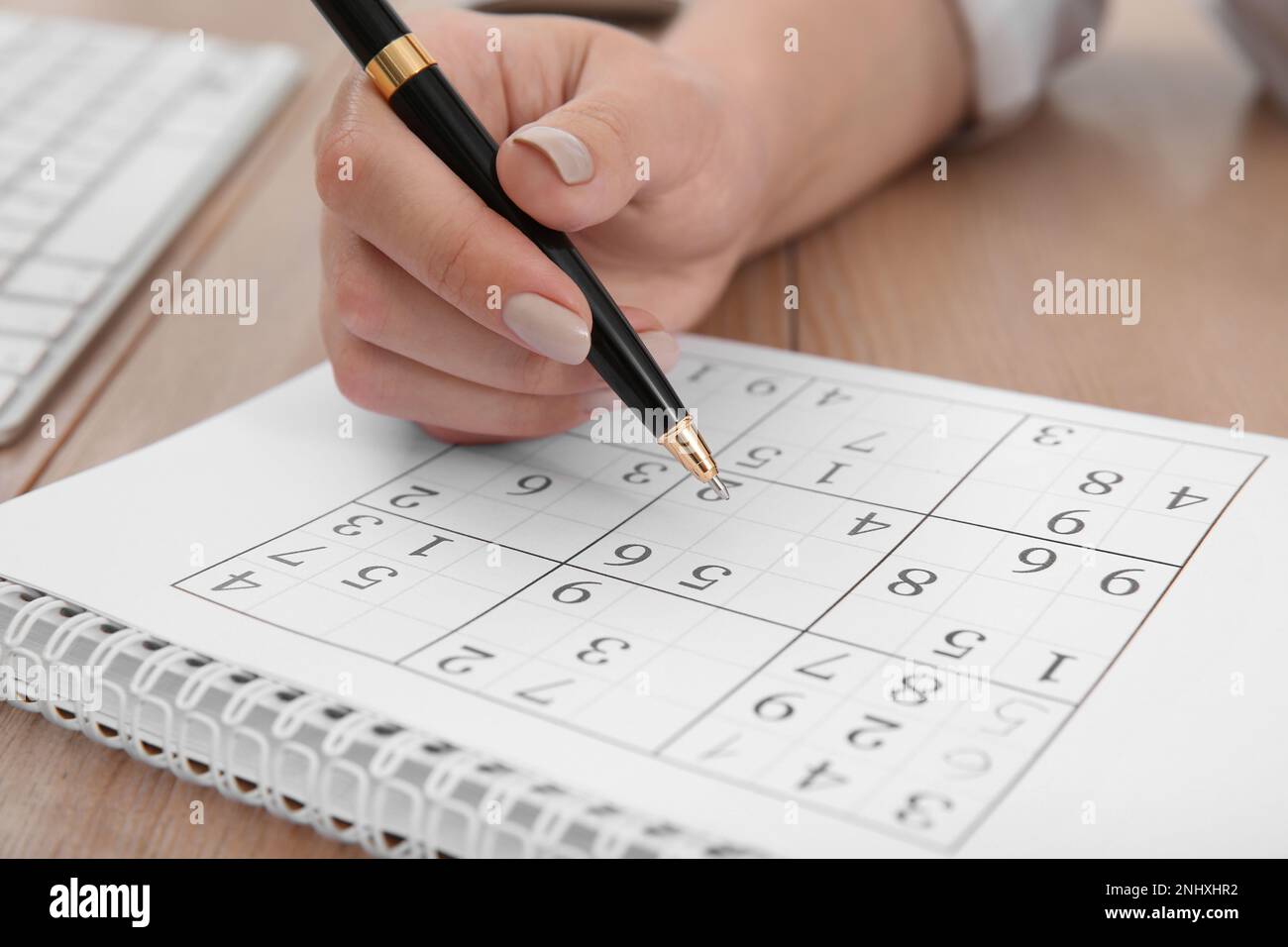 Femme résolvant sudoku puzzle à la table, gros plan Banque D'Images
