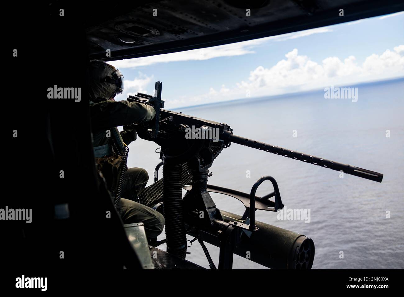 ÉTATS-UNIS Corps maritime Gunnery Sgt. Joe Thomas, chef d'équipage du Marine Light Attack Helicopter Squadron (HMLA), 469 tire un GAU-21 au large de la côte d'Okinawa, Japon, le 3 août 2022. La MLA-469 a mené un exercice de coordination et de reconnaissance des grèves afin d'accroître la compétence et la létalité dans l'ensemble de l'escadron. Banque D'Images