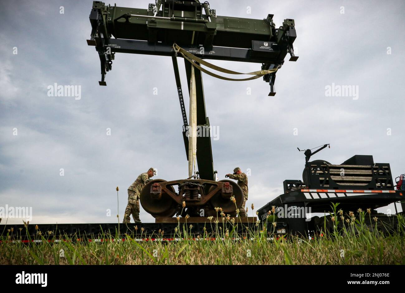 Les soldats de la Garde nationale de l'armée de l'Iowa du Camp Dodge Department of public Works and Sustainment Training Center ont sécurisé un ensemble de camions de wagons historiques pour le transport à Camp Dodge à Johnston, Iowa, le 3 août 2022. Trois wagons à plateau, une rampe et une courte longueur de voie ont été installés sur Camp Dodge en 1980s et ont servi de site d'entraînement de charge ferroviaire pour les soldats pendant plusieurs années avant que les opérations ferroviaires ne soient devenues largement obsolètes dans la Garde nationale de l'Iowa. Les wagons tournent sur les chariots à roulement à friction d'origine, qui ne sont plus utilisés dans les chemins de fer modernes à roulement à rouleaux. Plutôt que de mettre au rebut Banque D'Images