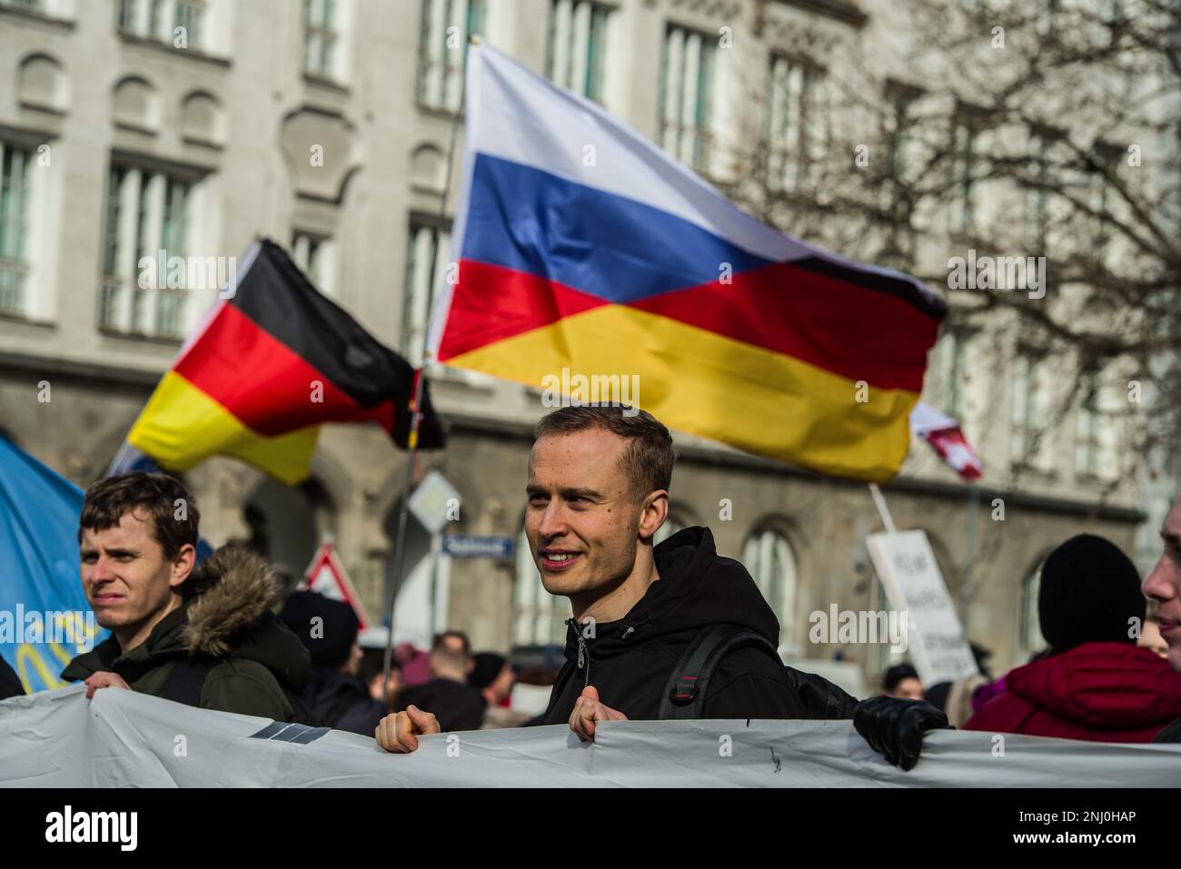 Munich, Bavière, Allemagne. 18th févr. 2023. Ncolas Brickenstein de l'AfD avec un drapeau russe-allemand fusionné derrière lui souvent associé à l'idéologie conspirationniste ''Gerussia'. En collaboration avec Jürgen Elsà¤sser (Juergen Elsaesser) de l'extrême droite Compact Magazine, l'alternative pour l'Allemagne (alternative fuer Deutschland) a organisé une démonstration avec Petr Bystron et d'autres pour protester contre ce qu'ils perçoivent comme une politique anti-Poutine en Allemagne. (Credit image: © Sachelle Babbar/ZUMA Press Wire) USAGE ÉDITORIAL SEULEMENT! Non destiné À un usage commercial ! Banque D'Images