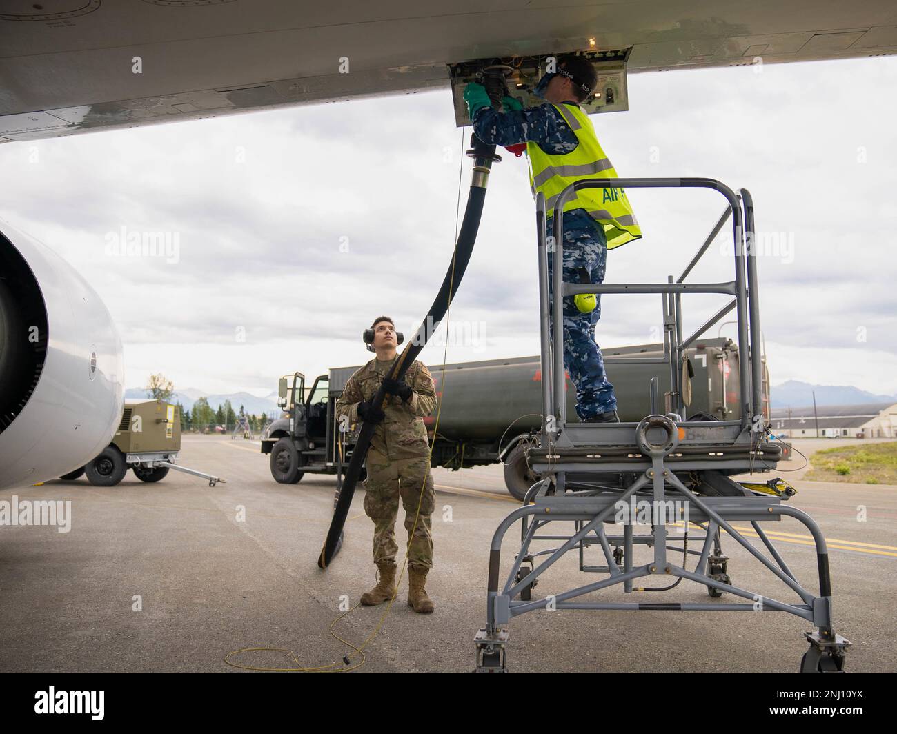 ÉTATS-UNIS Air Force Airman 1st classe Christopher Hernandez, 673d Logistics Readiness Squadron opérateur de distribution de carburant, remet un tuyau de carburant au caporal de la Royal Australian Air Force Tyron Houston, technicien d'aéronef du 2 Escadron, pendant LE DRAPEAU ROUGE Alaska 22-3 à la base interarmées Elmendorf-Richardson (Alaska), le 4 août 2022. L'alliance entre les États-Unis et l'Australie est un point d'ancrage pour la paix et la stabilité dans la région Indo-Pacifique et dans le monde entier. Banque D'Images