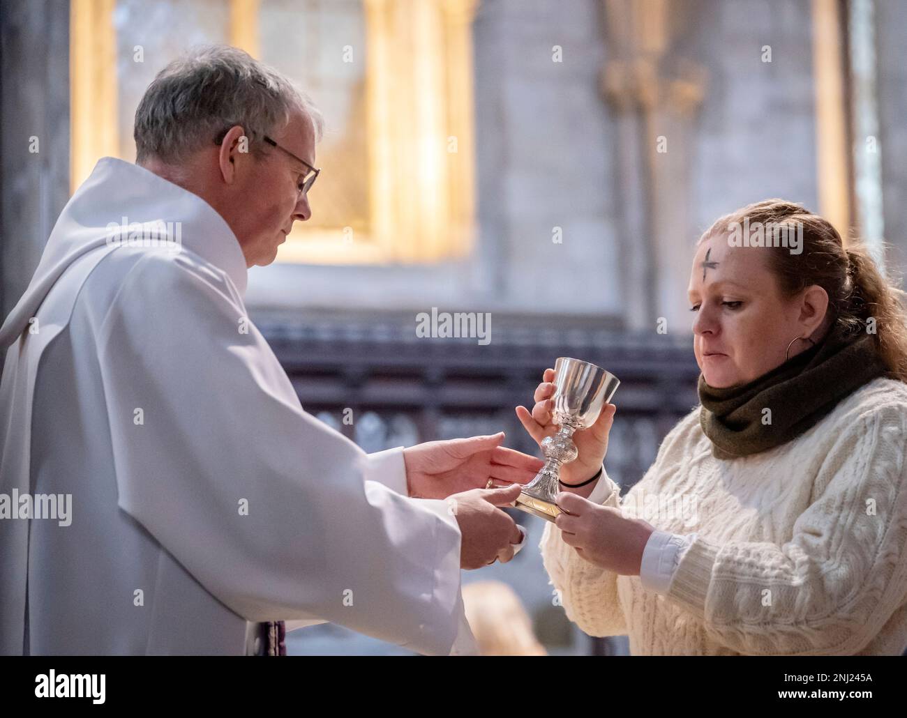 Canon Michael Gisbourne (à gauche) avec un membre de la congrégation qui a une croix de cendres sur son front, après l'imposition des cendres pendant l'Eucharistie du mercredi des cendres à la cathédrale de Ripon dans le North Yorkshire. Date de la photo: Mercredi 22 février 2023. Banque D'Images