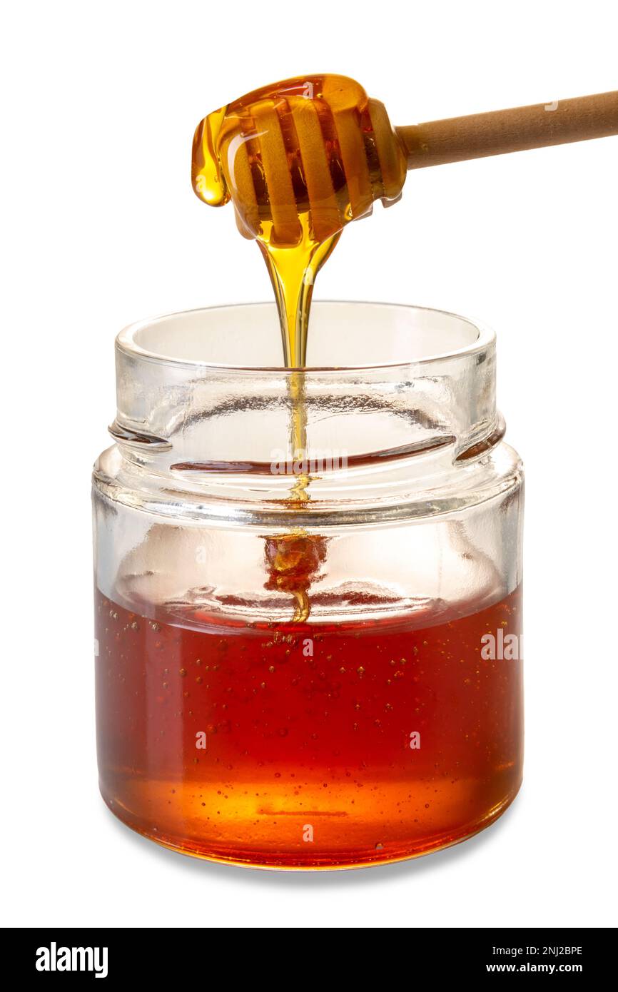 Miel goutte de miel en bois de la louche de miel dans un pot en verre, miel de châtaignier de couleur ambre, isolé sur blanc avec un chemin de coupure Banque D'Images