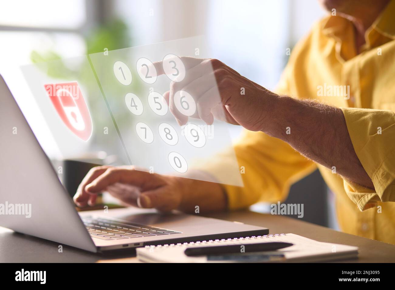 Concept de sécurité en ligne avec un homme utilisant un ordinateur portable avec superposition graphique du verrou et clavier numérique PIN Banque D'Images