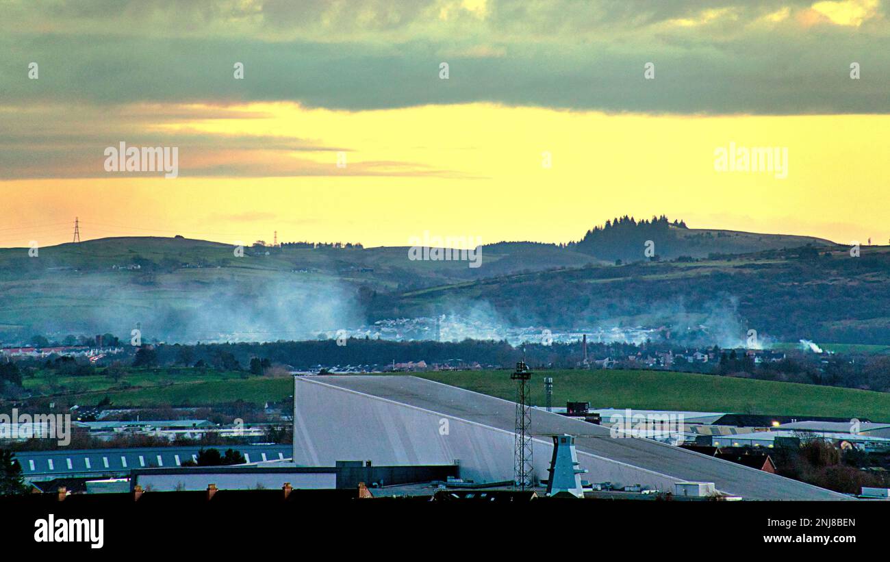 Glasgow, Écosse, Royaume-Uni 21st février 2023. Le feu pousse la fumée au-dessus de la ville au coucher du soleil car il semble aller de Paisley à la ville. Photo à 11 kilomètres de Credit Gerard Ferry/Alay Live News Banque D'Images
