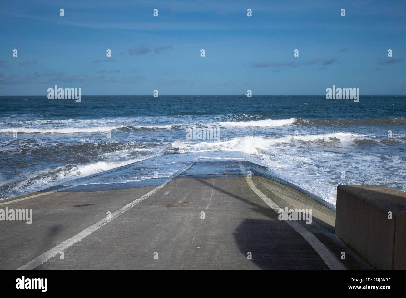 Mer du Nord à marée haute avec des vagues se brisant sur un dérapage où des bateaux de sauvetage peuvent être lancés à Redcar Banque D'Images