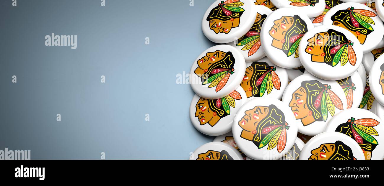 Logos de l'équipe LNH de la Ligue américaine de hockey les Blackhawks de Chicago sur un tas sur une table. Banque D'Images