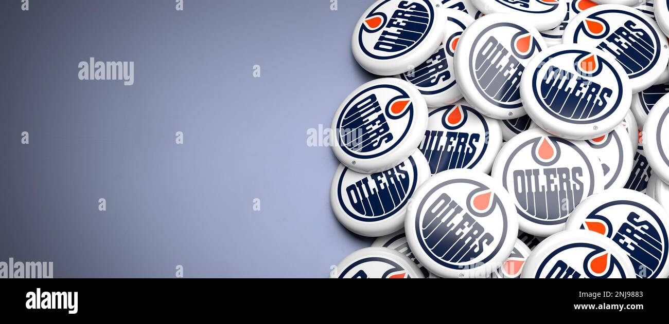 Logos de l'équipe LNH de la Ligue américaine de hockey les Oilers d'Edmonton sur un tas sur une table. Banque D'Images