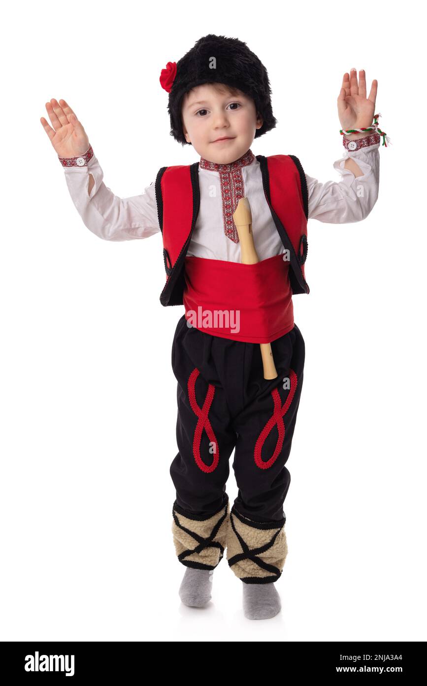 Garçon bulgare en costumes traditionnels folkloriques avec fleurs printanières en forme de goutte d'eau et bracelet en laine martenitsa symbole de Baba Marta Banque D'Images