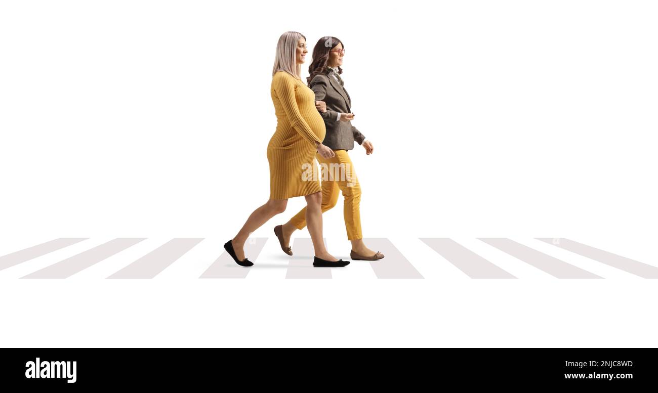 Femme enceinte marchant et tenant une autre femme sous le bras sur un passage piéton isolé sur fond blanc Banque D'Images