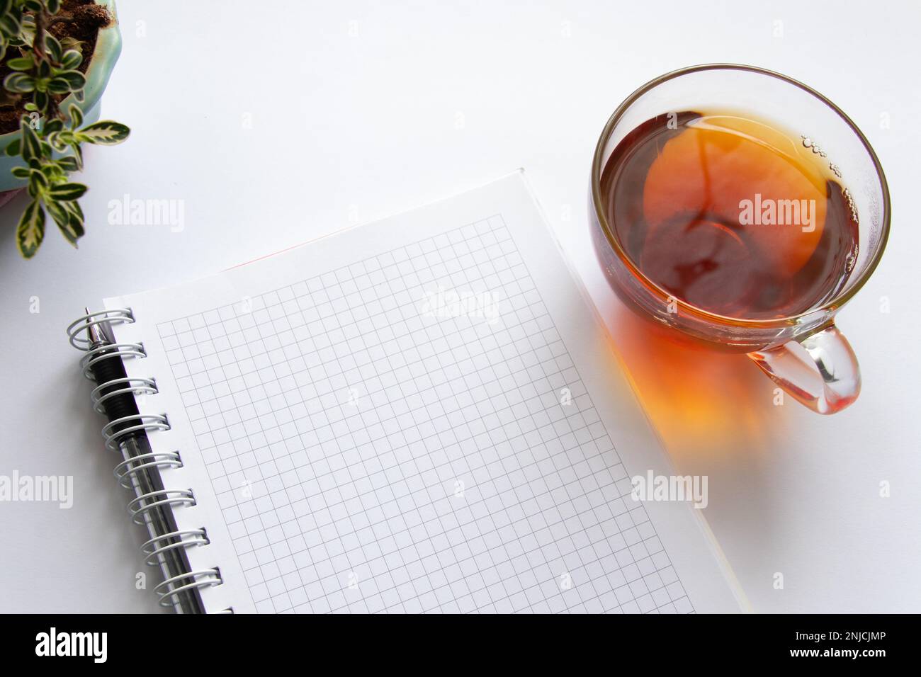 carnet et tasse de thé chaud sur fond blanc Banque D'Images