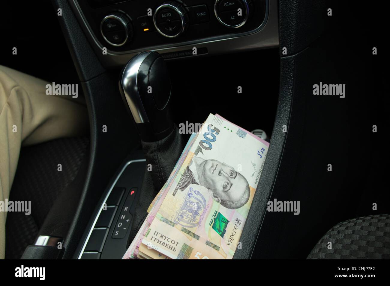 L'argent ukrainien 200 et 500 est détenu par une fille dans les mains de sa propre voiture, de l'argent pour une voiture Banque D'Images