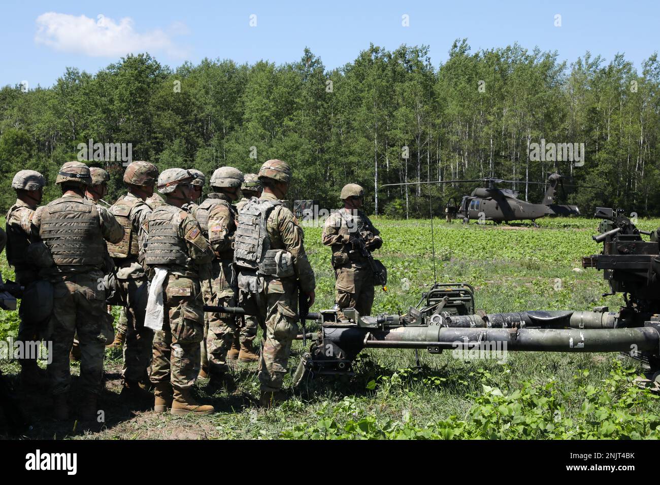 ÉTATS-UNIS Les soldats de l'armée, Alpha Battery, 1-134th Field Artillery Regiment, Garde nationale de l'Ohio, regardent quatre UH-60 Blackhawks atterrir pendant la grève du Nord 22-2, au Camp Grayling, au Michigan, le 10 août 2022. La grève du Nord offre aux unités d'artillerie la possibilité d'exécuter un feu réel dans un environnement multicomposant, avec des feux communs. Banque D'Images